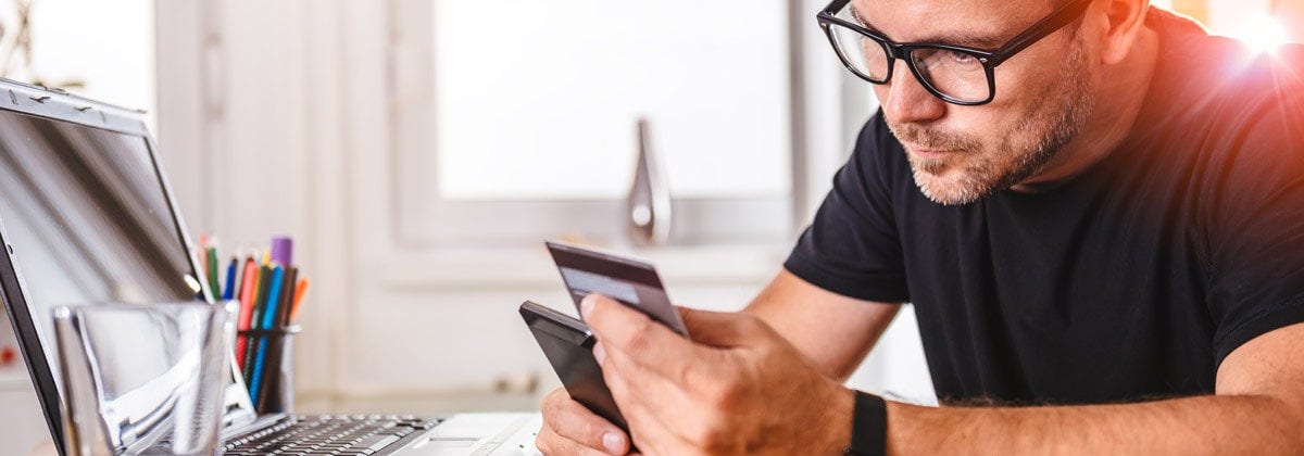 man on computer with credit card